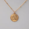 Closeup on coin design of the angel baby coin necklace.  Angel is depicted from the chest up and is resting his chin in one hand.