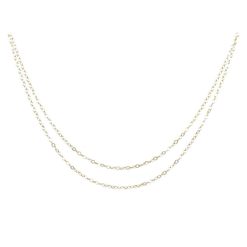 Two delicate gold layered flat cable chains.