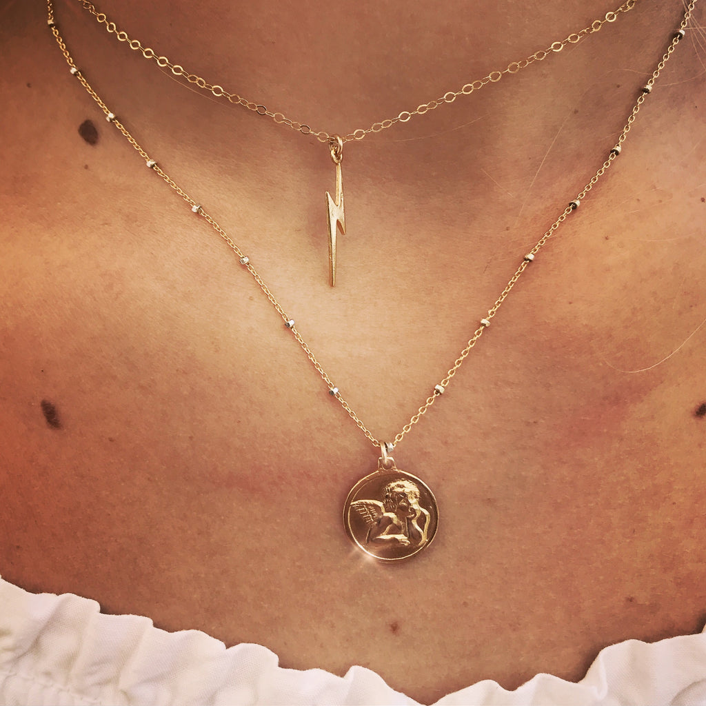 16" Angel Baby Coin Necklace on a model, layered with our lightning bolt choker.